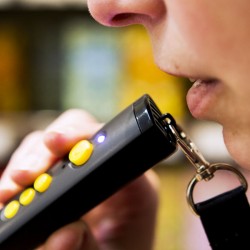 un lecteur vocal d'étiquettes tenu en main par une personne en train d'enregistrer un message vocal