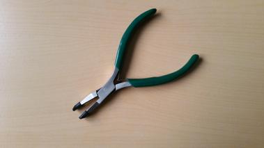 Pince de précision pour arthrose posée sur une table