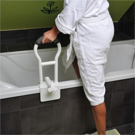 Personne avec un peignoir blanc entrant dans une baignoire à l'aide d'une poignée de rebord