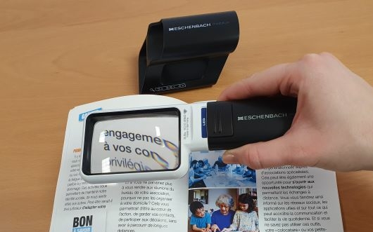 Loupe éclairante avec socle tenue par une main