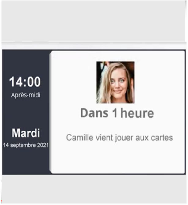 écran de tablette simplifiée indiquant l'heure, le moment de la journée, la date et jour de la semaine, une photo affichée avec rappel écrit