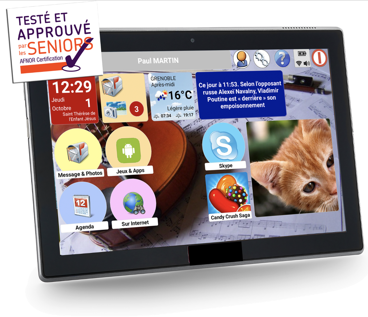 Écran de tablette avec 6 icônes de fonctionnalités Messages et photos, Jeux et Apps, Skype, Agenda, Sur Internet et Candy Crush Saga. 4 Icônes placées sur le haut de l'écran affichent la date et le saint du jour, îcones indiquant nouveaux messages et photos, la météo et une information.